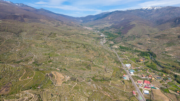 Aerial view of a valley with terraced fields leading up to rugged mountains their peaks dusted with snow Cabezuela del Valle Extremadura Spain.