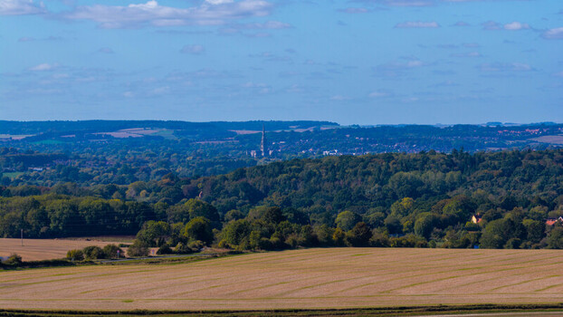 Aerial view of the rolling landscape and forests seen from Pepperbox Hill with the distant spire of Salisbury Cathedral rising above the horizon in Salisbury England United Kingdom. Aerial view of the rolling landscape and forests seen from Pepperbox Hill with the distant spire of Salisbury Cathedral rising above the horizon in Salisbury England United Kingdom.