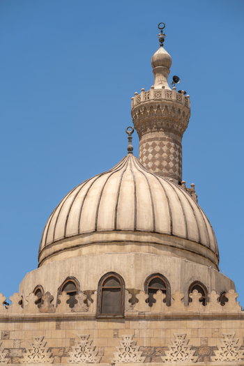 View of Al Azhar Mosque featuring its detailed stone dome and elegant minaret against a clear blue sky Cairo Egypt. View of Al Azhar Mosque featuring its detailed stone dome and elegant minaret against a clear blue sky Cairo Egypt.