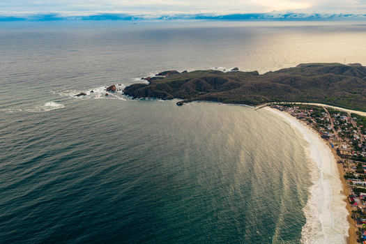 Aerial view of Playa Punta Perula with its sandy coastline turquoise waters and surrounding lush hills in Perula Jalisco Mexico. Aerial view of Playa Punta Perula with its sandy coastline turquoise waters and surrounding lush hills in Perula Jalisco Mexico.