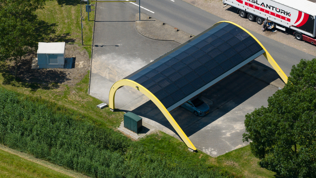 Middenbeemster Netherlands 20 June 2026 Aerial view of Fastned charging station with solar panel roof parked electric vehicle and nearby road infrastructure.