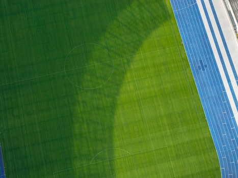 Berlin Germany 26 September 2026 Aerial view of Olympiastadion Berlin featuring a vibrant green soccer pitch and a blue running track under natural daylight.