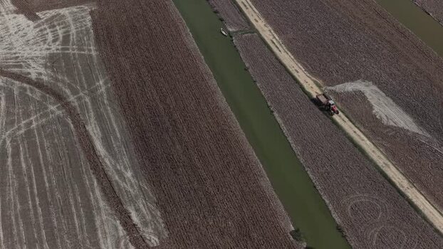 Aerial view of a tractor driving along a canal Portugal. Aerial view of a tractor driving along a canal Portugal.