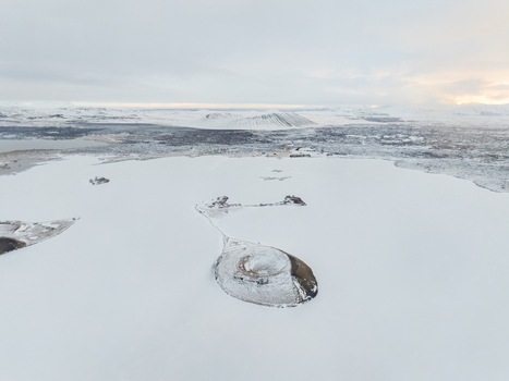 Aerial view of Myvatn lake covered in snow and ice with volcanic craters and islands under a soft overcast sky in Thingeyjarsveit Iceland. Aerial view of Myvatn lake covered in snow and ice with volcanic craters and islands under a soft overcast sky in Thingeyjarsveit Iceland.