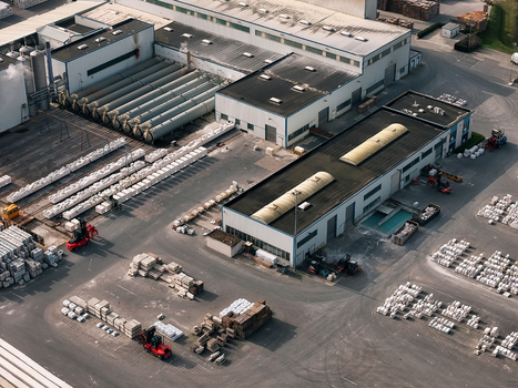 Aerial view of an industrial facility featuring large storage tanks warehouse buildings and forklifts moving pallets of materials in Dulmen North Rhine Westphalia Germany. Aerial view of an industrial facility featuring large storage tanks warehouse buildings and forklifts moving pallets of materials in Dulmen North Rhine Westphalia Germany.
