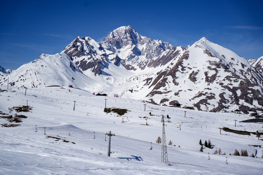 Aerial view of the snow covered peaks of the Mont Blanc massif and ski slopes with lift infrastructure under a clear blue sky in La Thuile Valle d Aosta Italy. Aerial view of the snow covered peaks of the Mont Blanc massif and ski slopes with lift infrastructure under a clear blue sky in La Thuile Valle d Aosta Italy.
