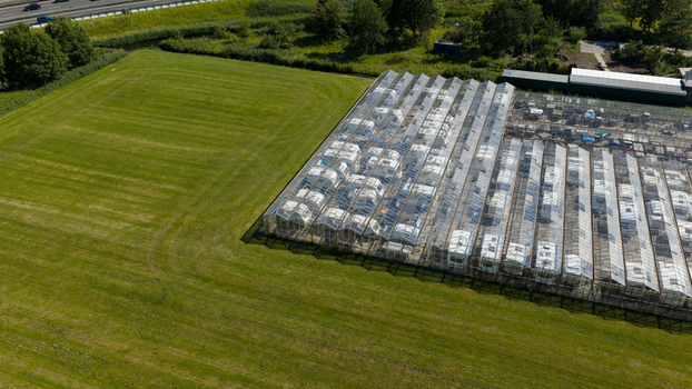 Aerial view of Caravanstalling Klijn a large greenhouse structure used for storing caravans situated next to a green field and a highway in Alkmaar Noord Holland Netherlands. Aerial view of Caravanstalling Klijn a large greenhouse structure used for storing caravans situated next to a green field and a highway in Alkmaar Noord Holland Netherlands.