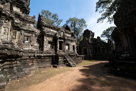 View of the ancient stone architecture and intricate carvings of Angkor Wat temple complex with wooden stairs and sandy ground in Krong Siem Reap Siem Reap Province Cambodia. View of the ancient stone architecture and intricate carvings of Angkor Wat temple complex with wooden stairs and sandy ground in Krong Siem Reap Siem Reap Province Cambodia.