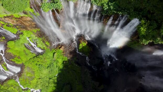 Aerial view of Grojogan Sewu Waterfall cascading down lush cliffs Indonesia. Aerial view of Grojogan Sewu Waterfall cascading down lush cliffs Indonesia.