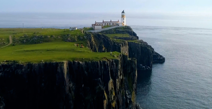 Aerial view of Neist Point Lighthouse perched on dramatic cliffs with lush green grass and the vast sea in the background Isle of Skye Scotland United Kingdom. Aerial view of Neist Point Lighthouse perched on dramatic cliffs with lush green grass and the vast sea in the background Isle of Skye Scotland United Kingdom.