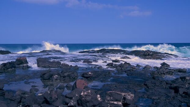View of waves crashing on the rocks at Kalaemamo United States.