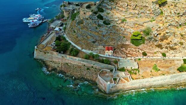 Aerial view of Spinalonga fortress and boats in Greece.