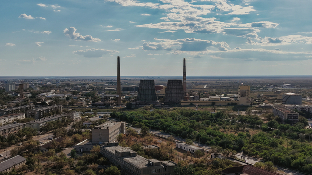 Aerial view of the Baikonur Cosmodrome power plant featuring large cooling towers and tall chimneys set against an arid landscape in Karmakshy District Kyzylorda Region Kazakhstan.