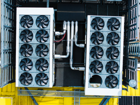Aerial view of industrial cooling units with multiple fans installed on a yellow rooftop in Valdlauci Kekava Municipality Latvia. Aerial view of industrial cooling units with multiple fans installed on a yellow rooftop in Valdlauci Kekava Municipality Latvia.