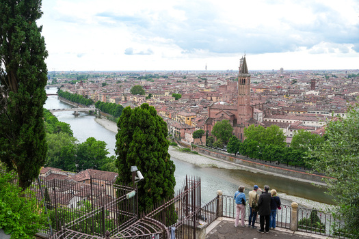 Aerial view of the Adige river and the historic Santa Anastasia church tower with tourists on a terrace in Verona Veneto Italy.