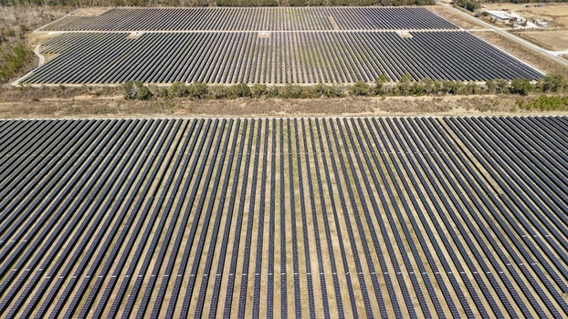 Aerial view of vast solar panel arrays stretching across the landscape reflecting the sky above Elkton Florida United States. Aerial view of vast solar panel arrays stretching across the landscape reflecting the sky above Elkton Florida United States.
