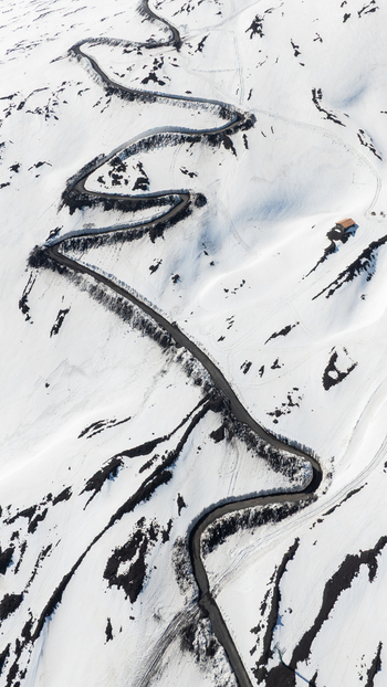 Aerial view of a winding mountain road with hairpin turns on the snow covered slopes of the south side of Mount Etna in Nicolosi Sicilia Italy. Aerial view of a winding mountain road with hairpin turns on the snow covered slopes of the south side of Mount Etna in Nicolosi Sicilia Italy.