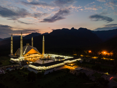 Aerial view of the illuminated Faisal Masjid at dusk with the Margalla Hills and a cloudy sky in Islamabad Islamabad Capital Ter Pakistan. Aerial view of the illuminated Faisal Masjid at dusk with the Margalla Hills and a cloudy sky in Islamabad Islamabad Capital Ter Pakistan.