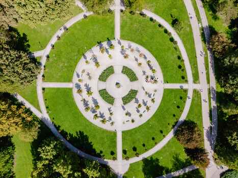 Aerial view of Tivoli Park featuring symmetrical circular pathways lush green lawns and manicured trees in the heart of the city in Ljubljana Slovenia.