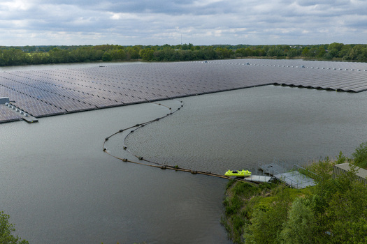 Aerial view of a large floating solar farm on a lake surrounded by lush green trees in Beilen Drenthe Netherlands. Aerial view of a large floating solar farm on a lake surrounded by lush green trees in Beilen Drenthe Netherlands.