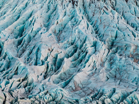 Aerial view of the deep blue crevasses and intricate ice formations of Svinafellsjokull glacier in Sveitarfelagid Hornafjordur Iceland. Aerial view of the deep blue crevasses and intricate ice formations of Svinafellsjokull glacier in Sveitarfelagid Hornafjordur Iceland.