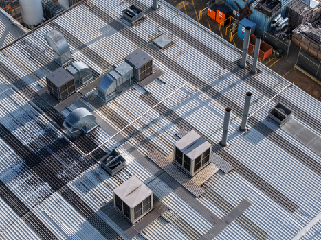 Aerial view of industrial factory roof with metal corrugated sheets ventilation units and exhaust pipes in Kilsyth South Melbourne VIC Australia. Aerial view of industrial factory roof with metal corrugated sheets ventilation units and exhaust pipes in Kilsyth South Melbourne VIC Australia.