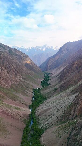 Aerial view of Qullai Vudor peak and a lush river valley Tajikistan. Aerial view of Qullai Vudor peak and a lush river valley Tajikistan.