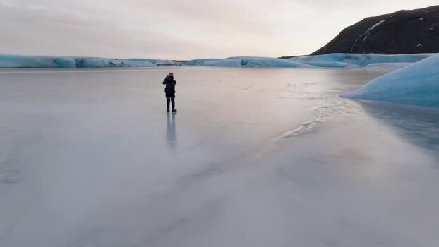 Aerial view of person on frozen glacial lake in Iceland. Aerial view of person on frozen glacial lake in Iceland.