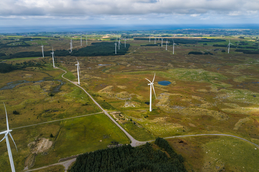 Aerial view of Hog Jaeren vindkraftverk wind farm with numerous white wind turbines scattered across the vast rolling green and brown landscape of Ha Municipality Rogaland Norway.