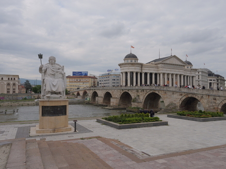 View of the historic Stone Bridge spanning the Vardar River with the statue of Justinian I in the foreground and neoclassical buildings in the background in Skopje North Macedonia. View of the historic Stone Bridge spanning the Vardar River with the statue of Justinian I in the foreground and neoclassical buildings in the background in Skopje North Macedonia.