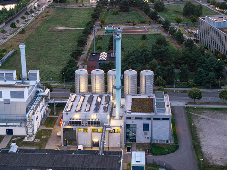 Berlin Germany 07 September 2026 Aerial view of BTB Heizkraftwerk Adlershof a modern power plant featuring industrial silos a tall chimney and green roofs in an urban setting.