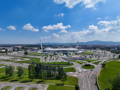 Torino Italy 09 May 2026 Aerial view of Allianz Stadium with its iconic white masts surrounding parking areas and the Alps in the background under a blue sky.