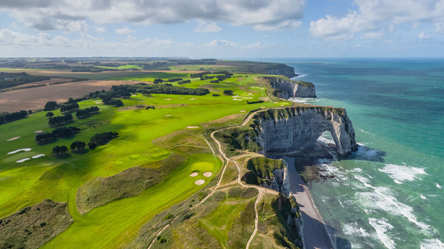 Aerial view of dramatic white cliffs meet the turquoise sea framing the iconic arch of &Eacute;tretat Normandy France.