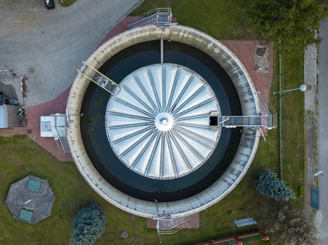 Aerial view of the circular sedimentation tank at the Dobczyce Wastewater Treatment Plant featuring a metallic roof structure and surrounding green grounds Dobczyce Lesser Poland Poland.