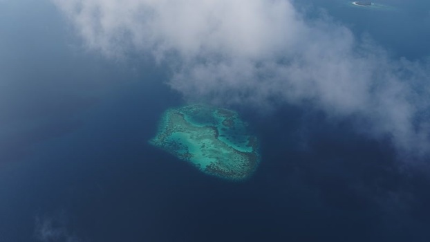 Aerial view of a turquoise coral reef under white clouds Maldives. Aerial view of a turquoise coral reef under white clouds Maldives.