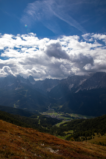 View of the Dolomites mountain range overlooking the village of Rocca Pietore nestled in a green valley under a cloudy sky in Rocca Pietore Veneto Italy. View of the Dolomites mountain range overlooking the village of Rocca Pietore nestled in a green valley under a cloudy sky in Rocca Pietore Veneto Italy.