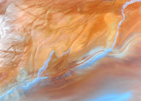 Aerial view of the vibrant orange mineral deposits and swirling textures of the Minas de Riotinto mining area in Minas de Riotinto Andalusia Spain.