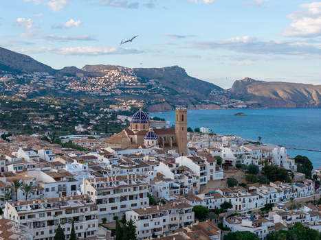 Aerial view of the Church of Our Lady of Consolation with blue tiled domes above white washed houses overlooking the Mediterranean Sea in Altea Valencian Community Spain.