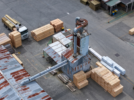 Melbourne VIC Australia 25 September 2026 Aerial view of a timber processing facility with stacks of lumber a truck and industrial machinery.