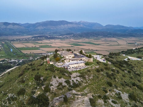 Aerial view of Lekuresi Castle situated on a hilltop overlooking the vast agricultural fields and distant mountains in Saranda Vlore County Albania. Aerial view of Lekuresi Castle situated on a hilltop overlooking the vast agricultural fields and distant mountains in Saranda Vlore County Albania.