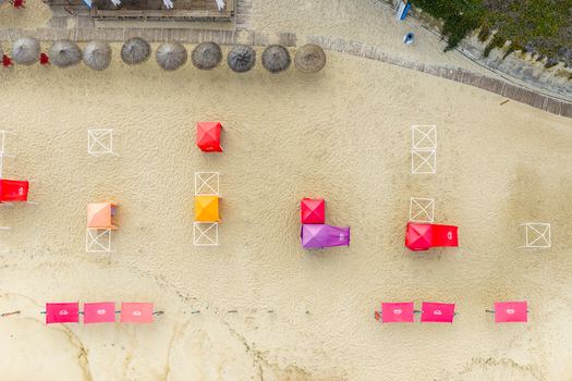 Aerial view of Praia de Sao Pedro de Moel with colorful sunshades tents and straw umbrellas on the golden sand Marinha Grande Leiria Portugal. Aerial view of Praia de Sao Pedro de Moel with colorful sunshades tents and straw umbrellas on the golden sand Marinha Grande Leiria Portugal.