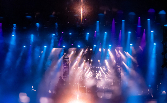 View of a concert stage illuminated by vibrant blue and purple spotlights with stage lighting rigs and atmospheric haze in Nyon Vaud Switzerland.
