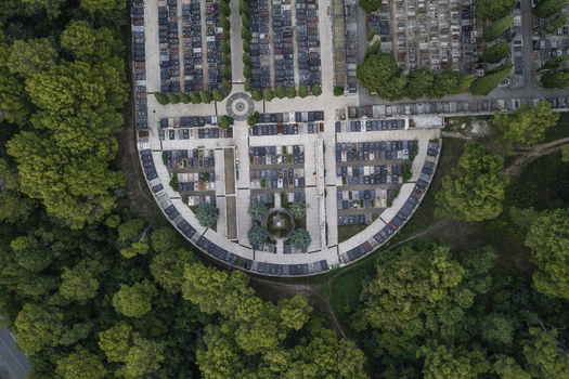 Aerial view of a cemetery with organized rows of graves and stone markers surrounded by lush green trees in Pula Istarska zupanija Croatia. Aerial view of a cemetery with organized rows of graves and stone markers surrounded by lush green trees in Pula Istarska zupanija Croatia.