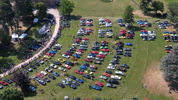 Francheleins France 04 June 2023 Aerial view of Chateau de Vataneins during a car show with rows of colorful vehicles on a green lawn and people walking along a path. Francheleins France 04 June 2023 Aerial view of Chateau de Vataneins during a car show with rows of colorful vehicles on a green lawn and people walking along a path.