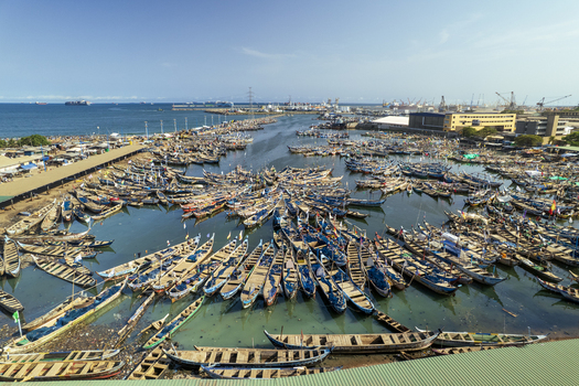 Aerial view of colorful boats clustered densely in the harbor reflecting the sunlight and activity around the port Tema Ghana. Aerial view of colorful boats clustered densely in the harbor reflecting the sunlight and activity around the port Tema Ghana.