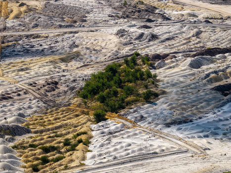Aerial view of Tagebau Welzow Sud brown coal open pit mine showing textured earth mounds industrial excavation patterns and green vegetation in Spremberg Brandenburg Germany. Aerial view of Tagebau Welzow Sud brown coal open pit mine showing textured earth mounds industrial excavation patterns and green vegetation in Spremberg Brandenburg Germany.
