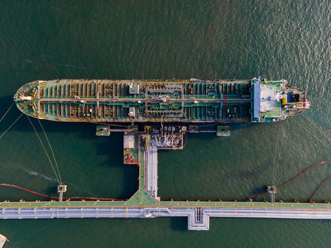Aerial view of an oil tanker docked at a marine terminal with industrial piping and infrastructure in the sea in Cilacap Regency Central Java Indonesia. Aerial view of an oil tanker docked at a marine terminal with industrial piping and infrastructure in the sea in Cilacap Regency Central Java Indonesia.