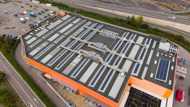 Aerial view of the OBI hardware store featuring a large flat roof with skylights and HVAC systems next to a parking lot and highway in San Giuliano Milanese Lombardia Italy. Aerial view of the OBI hardware store featuring a large flat roof with skylights and HVAC systems next to a parking lot and highway in San Giuliano Milanese Lombardia Italy.