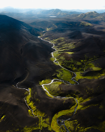 Aerial view of a river snaking through a stark volcanic landscape with contrasting black sands and vibrant green moss Highlands Iceland. Aerial view of a river snaking through a stark volcanic landscape with contrasting black sands and vibrant green moss Highlands Iceland.