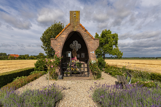 View of Kapel op De Heuvel with lavender bushes a gravel path and a wooden bench under a cloudy sky in Bemmel Gelderland Netherlands. View of Kapel op De Heuvel with lavender bushes a gravel path and a wooden bench under a cloudy sky in Bemmel Gelderland Netherlands.
